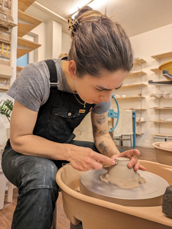 Agnieszka shaping clay on a pottery wheel